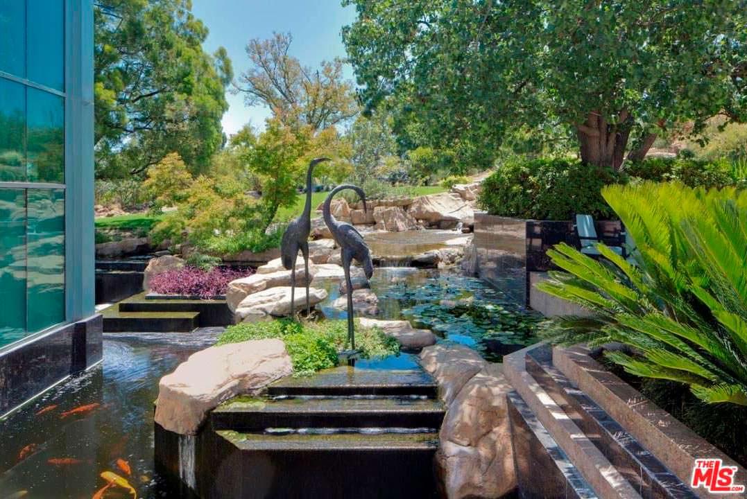 Рукотворный пруд со статуями фламинго за окном дома